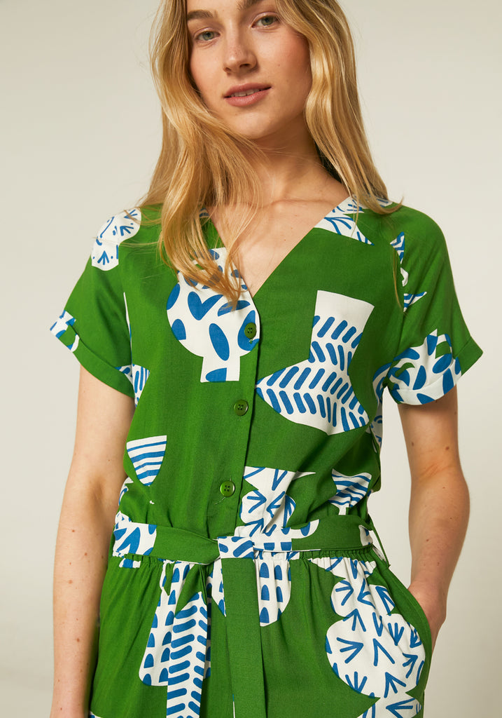 Model wearing a green compania fantastica dress with pottery print